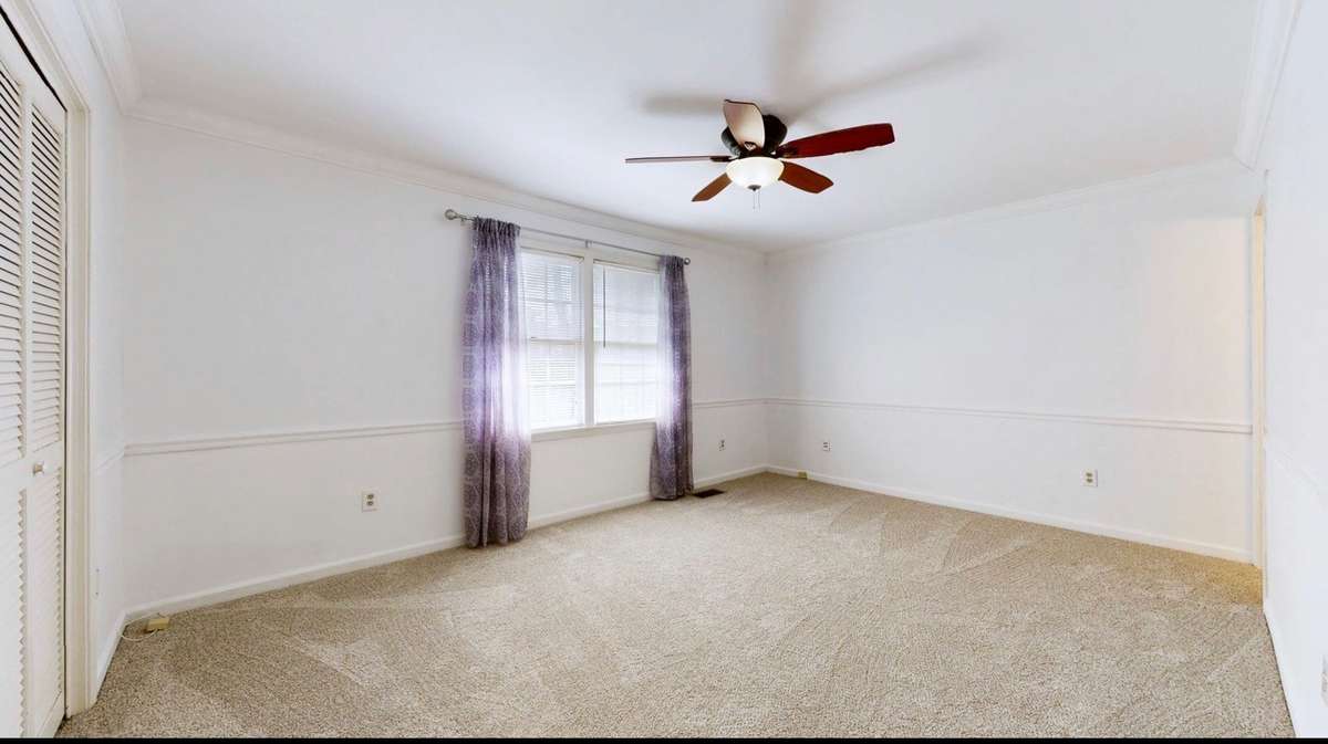 Primary Bedroom with ceiling fan and en-suite bath and NEW carpet.