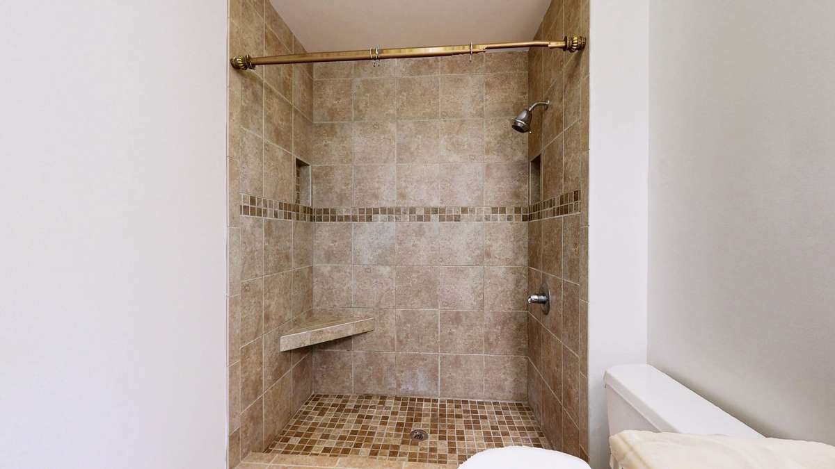 Large walk-in tile shower wiih seat.