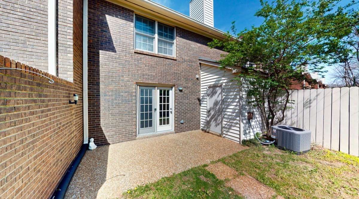 Fenced patio/yard with storage closet.