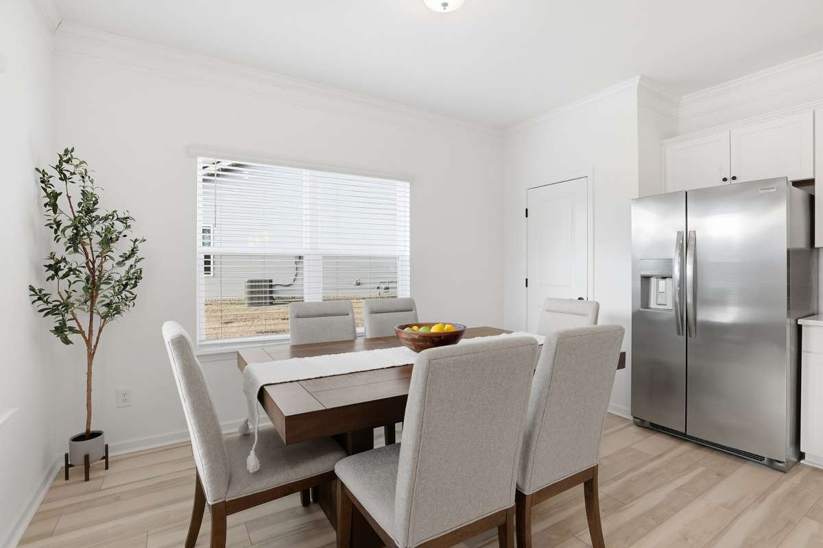Dining area with plenty of sunshine! Nice pantry next to refrigerator.