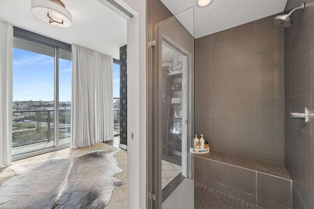 The view from the guest bath that has a large glass door/tiled walk in shower. The Murphy Bed is put away, allowing for multiple usage options