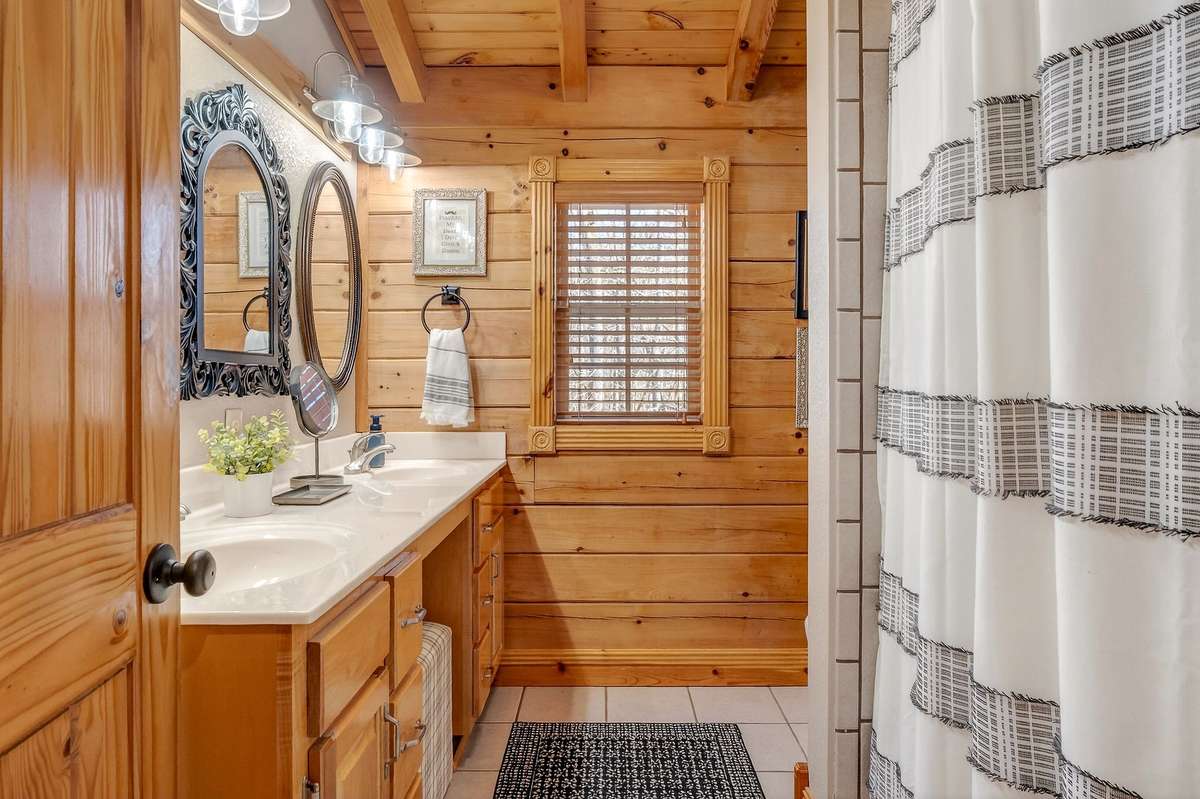 Upper bath featuring a double vanity, tub/shower combination.