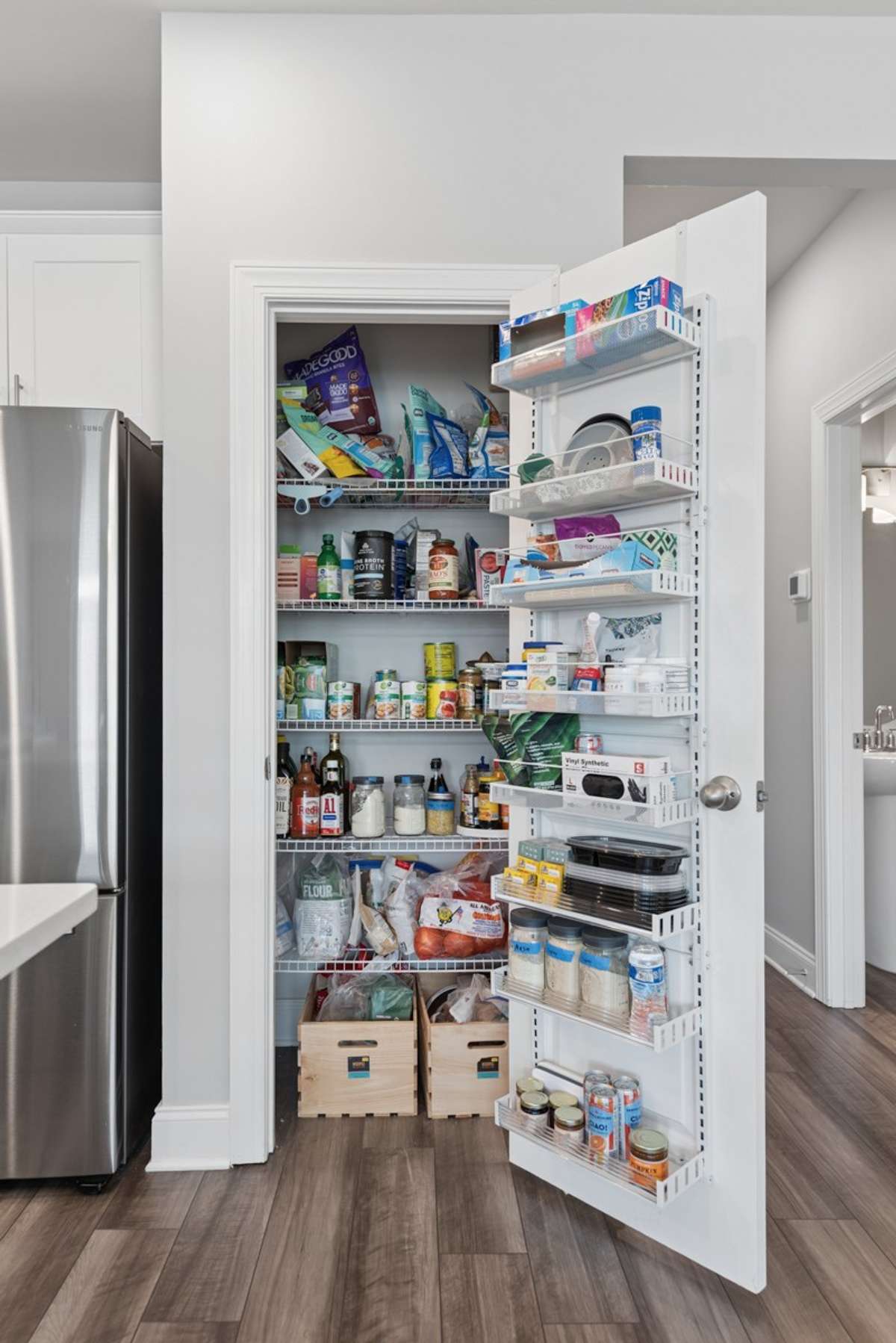 Spacious walk-in pantry with floor-to-ceiling shelving and door-mounted organizers — serious kitchen storage that truly delivers.
