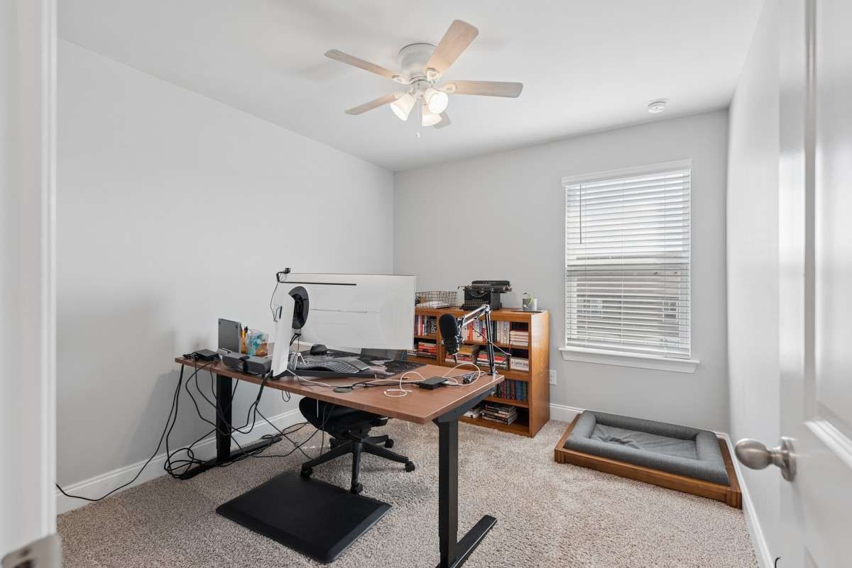 Versatile 2nd bedroom with plush carpet, ceiling fan, and natural light — equally suited as a home office, guest room, or hobby space.