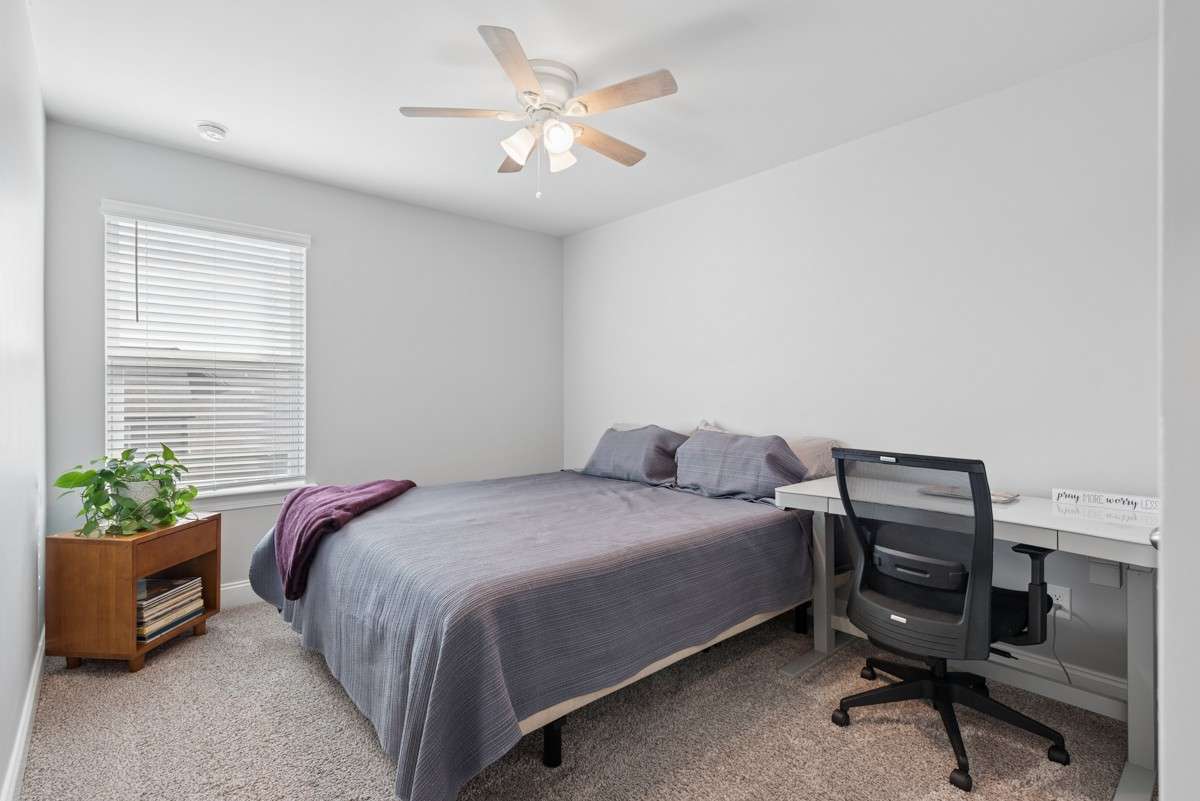 Comfortable 3rd bedroom with plush carpet, ceiling fan, and natural light — a flexible space ready to suit any need.
