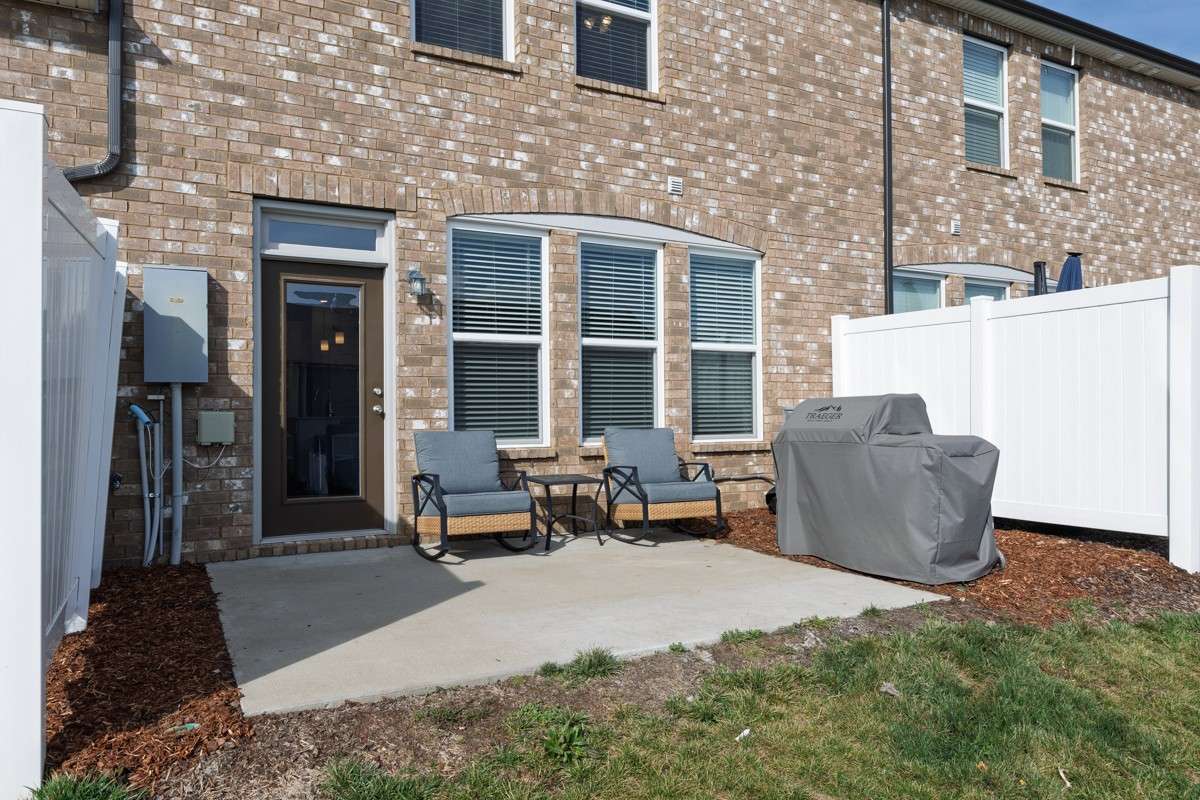 Classic brick exterior with a private patio, vinyl privacy fencing, and a spacious backyard area— a great outdoor space to relax and unwind.
