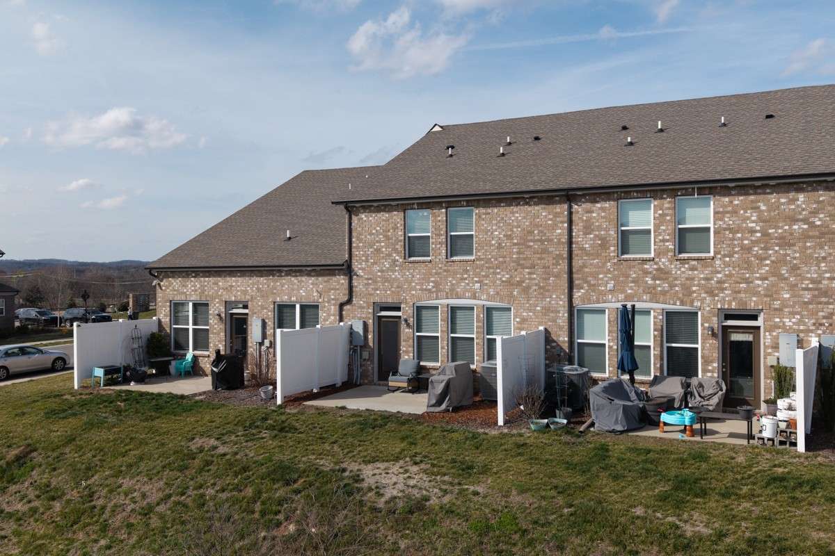 Classic brick exterior with a private patio, vinyl privacy fencing, and a spacious backyard area— a great outdoor space to relax and unwind.