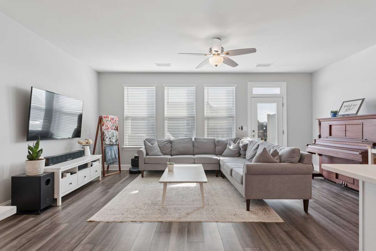 Bright, open, and generously sized — this living room features warm LVP floors, a wall of windows, and an easy flow to the rest of the main level. A great space to unwind or gather with guests.