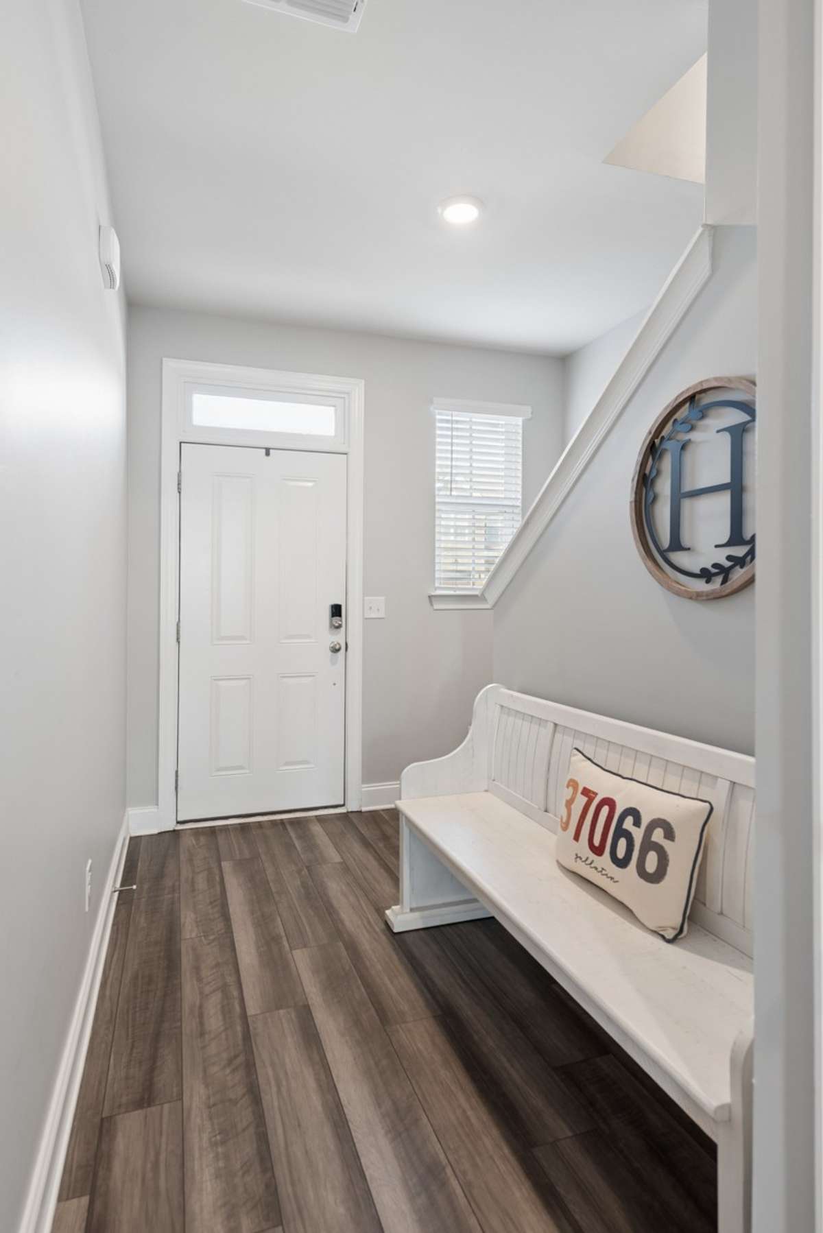 A gracious foyer sets the tone for this lovingly appointed home, where warm gray hardwood-style floors, classic white millwork, and an abundance of natural light speak to the quiet elegance of Southern living at its finest.