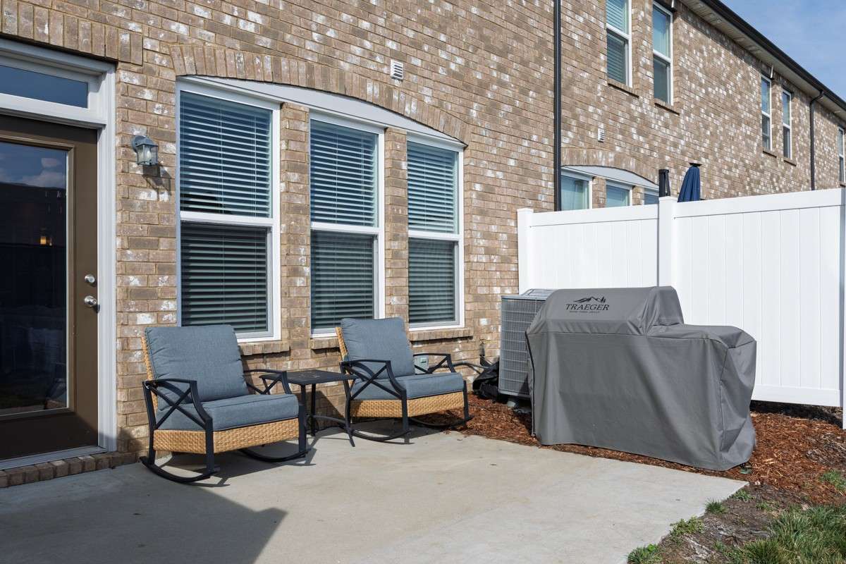 Classic brick exterior with a private patio, vinyl privacy fencing, and a spacious backyard area— a great outdoor space to relax and unwind.