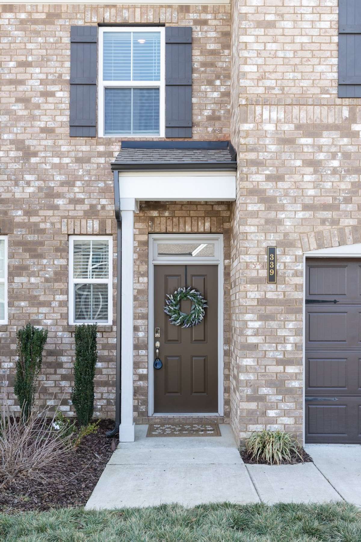 Welcome to 339 Cheval Drive — A charming covered entry with white columns, transom window, fresh sod, and manicured landscaping — a warm and polished first impression that carries throughout the entire home.