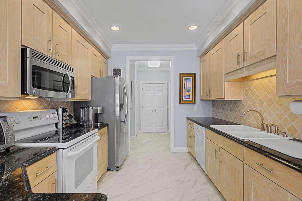 The kitchen has abundant cabinet space and counters. Refrigerator recently replaced.