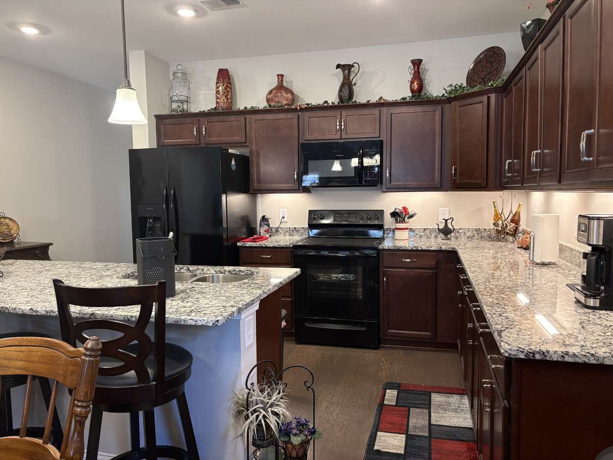 Kitchen enjoys plenty of storage and oversized island for meal prep and shared conversation