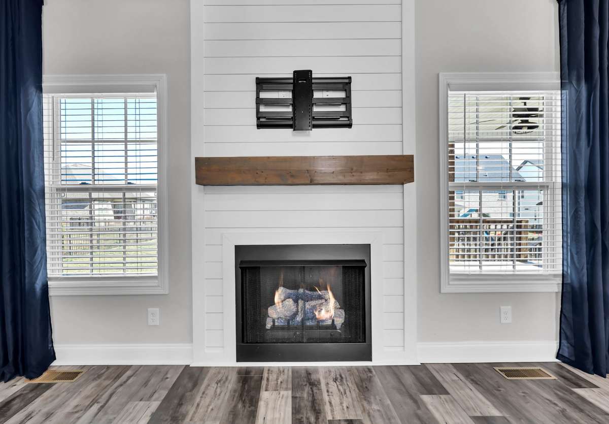 Flanked by windows that bring in natural light, this space feels bright, balanced, and inviting—making it the perfect centerpiece for gathering with family and friends.
