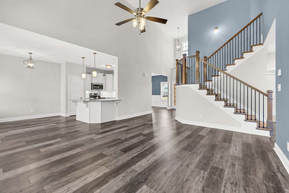 Natural light enhances the warm tones of the flooring, while the open design allows for flexible furniture placement and seamless connectivity throughout the home.