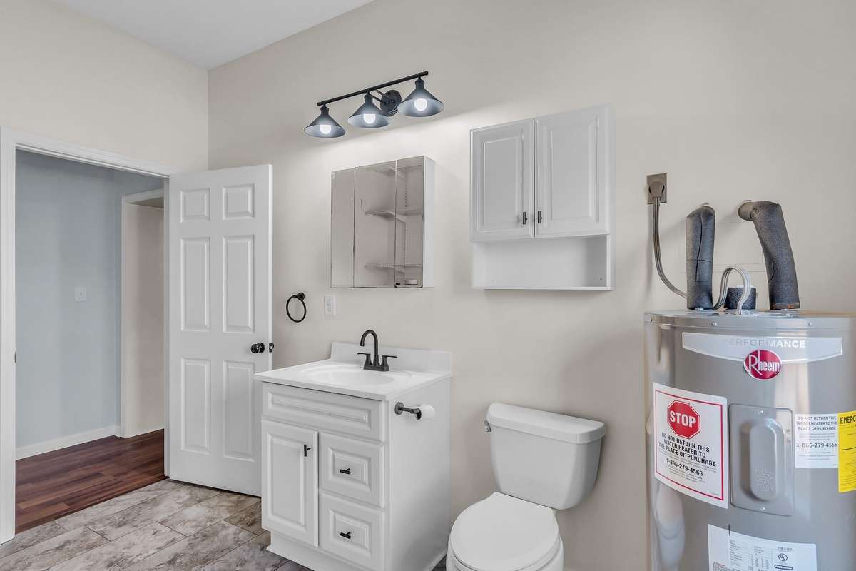 The conveniently located 1/2 bathroom also serves as the utility room.