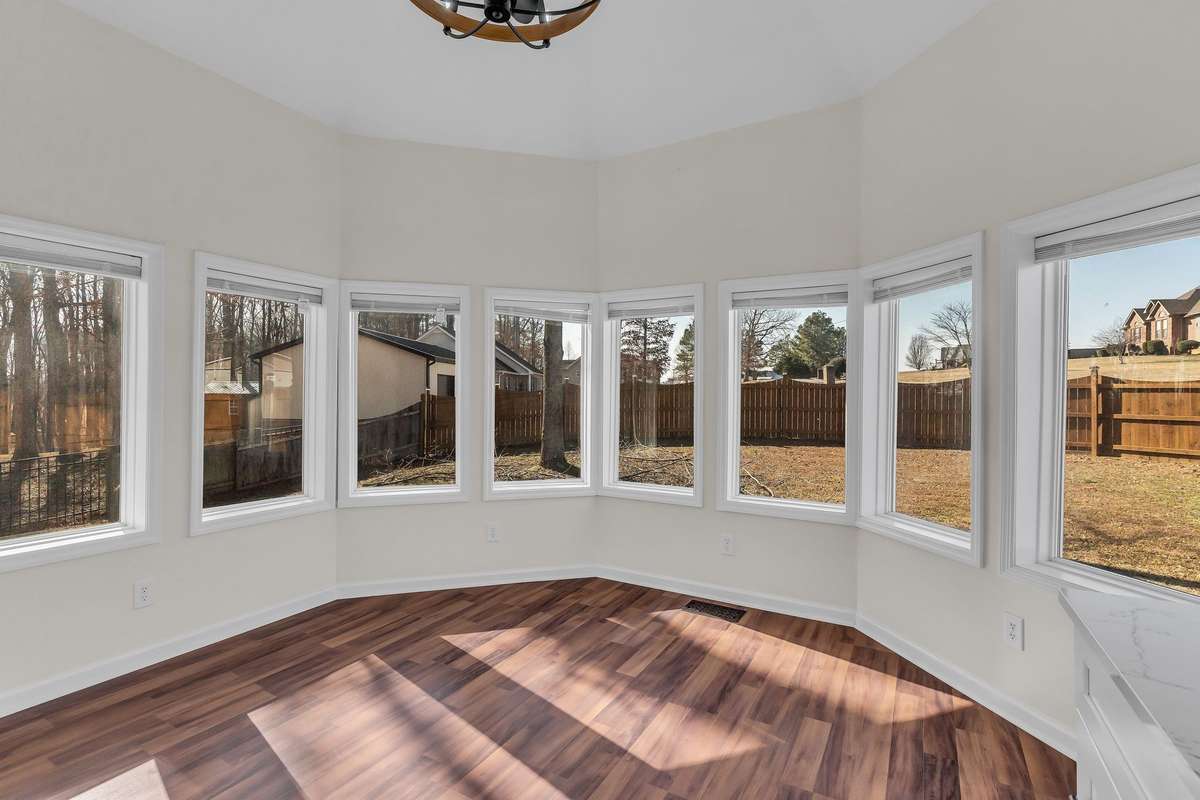 Bask in natural light in this stunning dining room, where a wrap-around perimeter of windows offers panoramic views of the sprawling landscape.