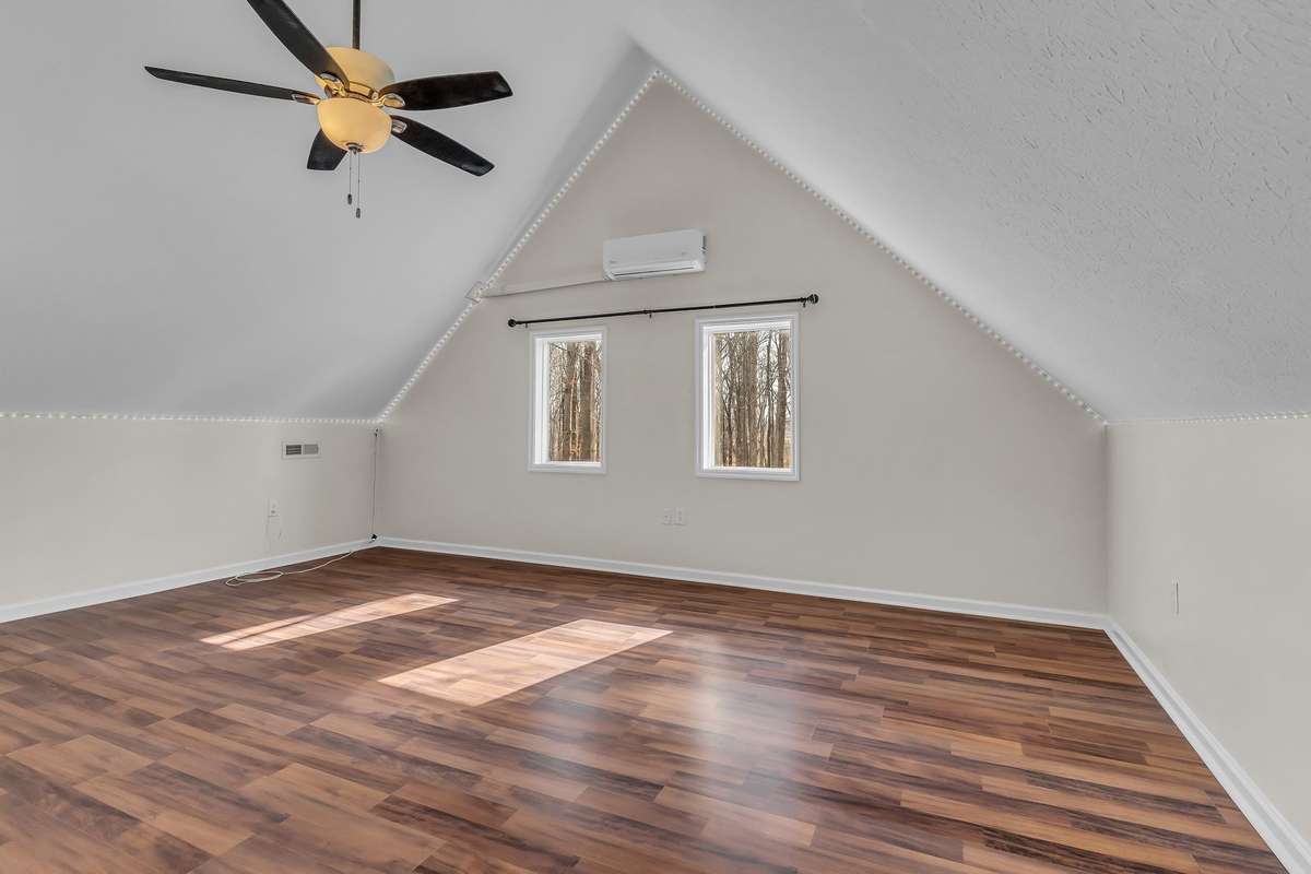 Up the spiral stairs is a large, enclosed loft that would work well for a bonus room, home office, or additional bedroom.