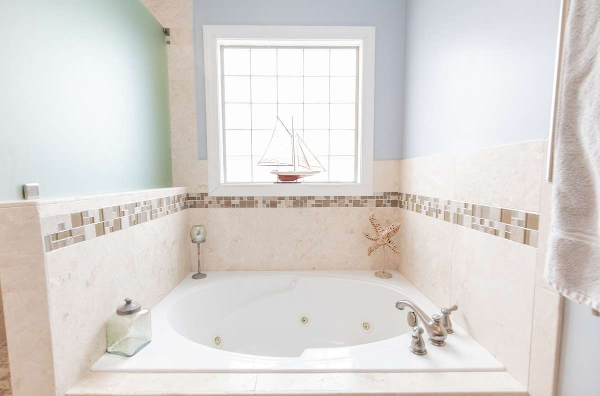 Large soaking tub with jets and natural light from window