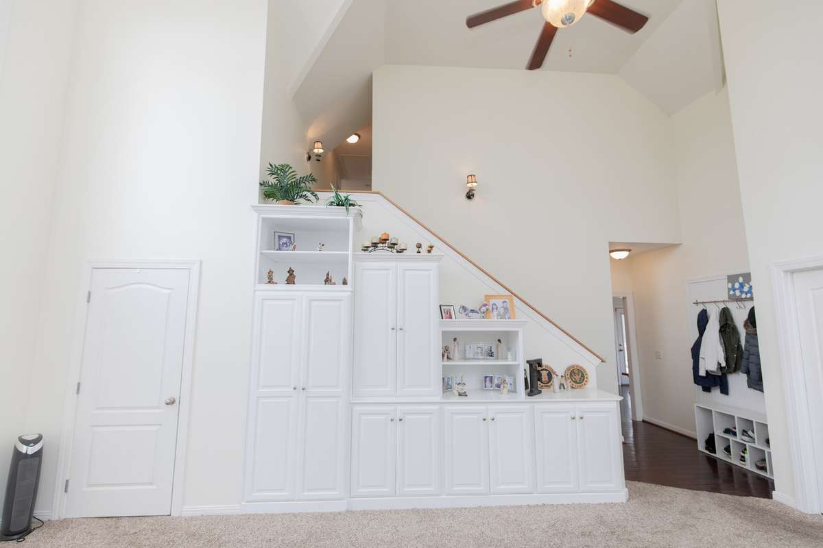 Laundry room behind door with lots of shelving and a wet sink