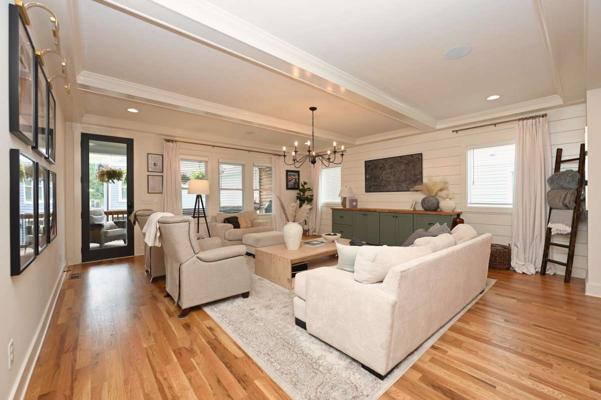 Huge open living room with beamed ceiling, shiplap and built in cabinetry