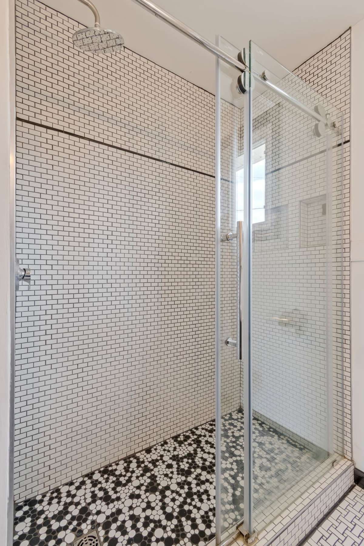 The tiled walk-in shower with glass panels is beautiful!