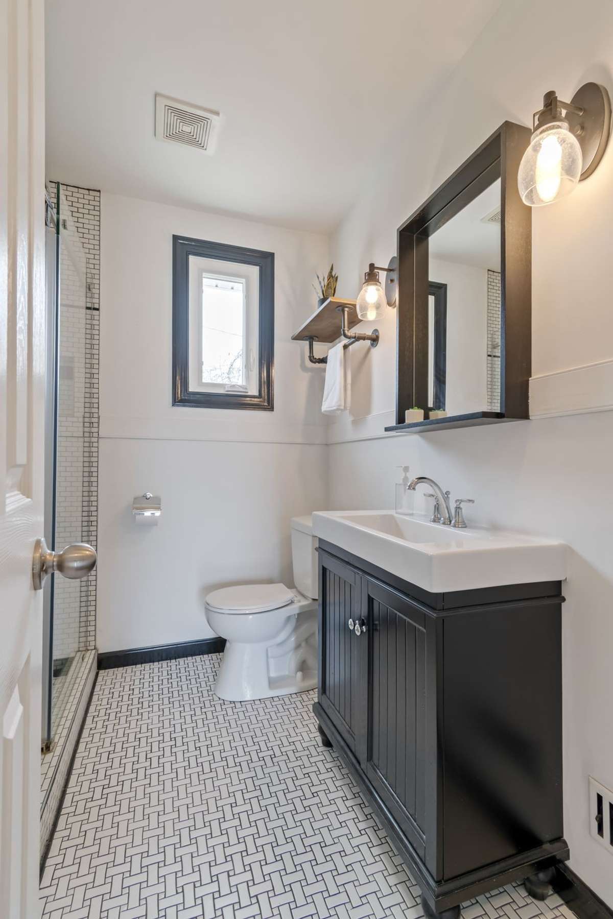 The basketweave tile on the bathroom floor makes the bathroom charming and inviting.