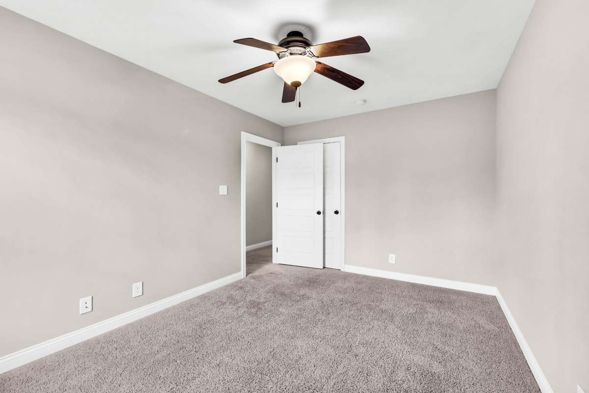 Bedroom three with ceiling fan. Buyer to select flooring for all carpeted areas, which is on-site.