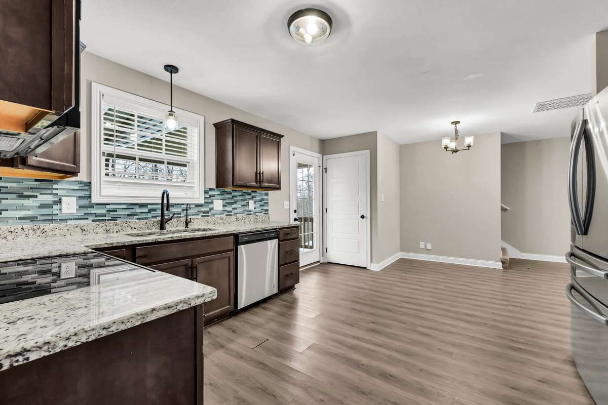 Big kitchen with granite counters, tile backsplash, stainless steel appliances, and pantry and half bath. Buyer may select flooring, which is on-site.