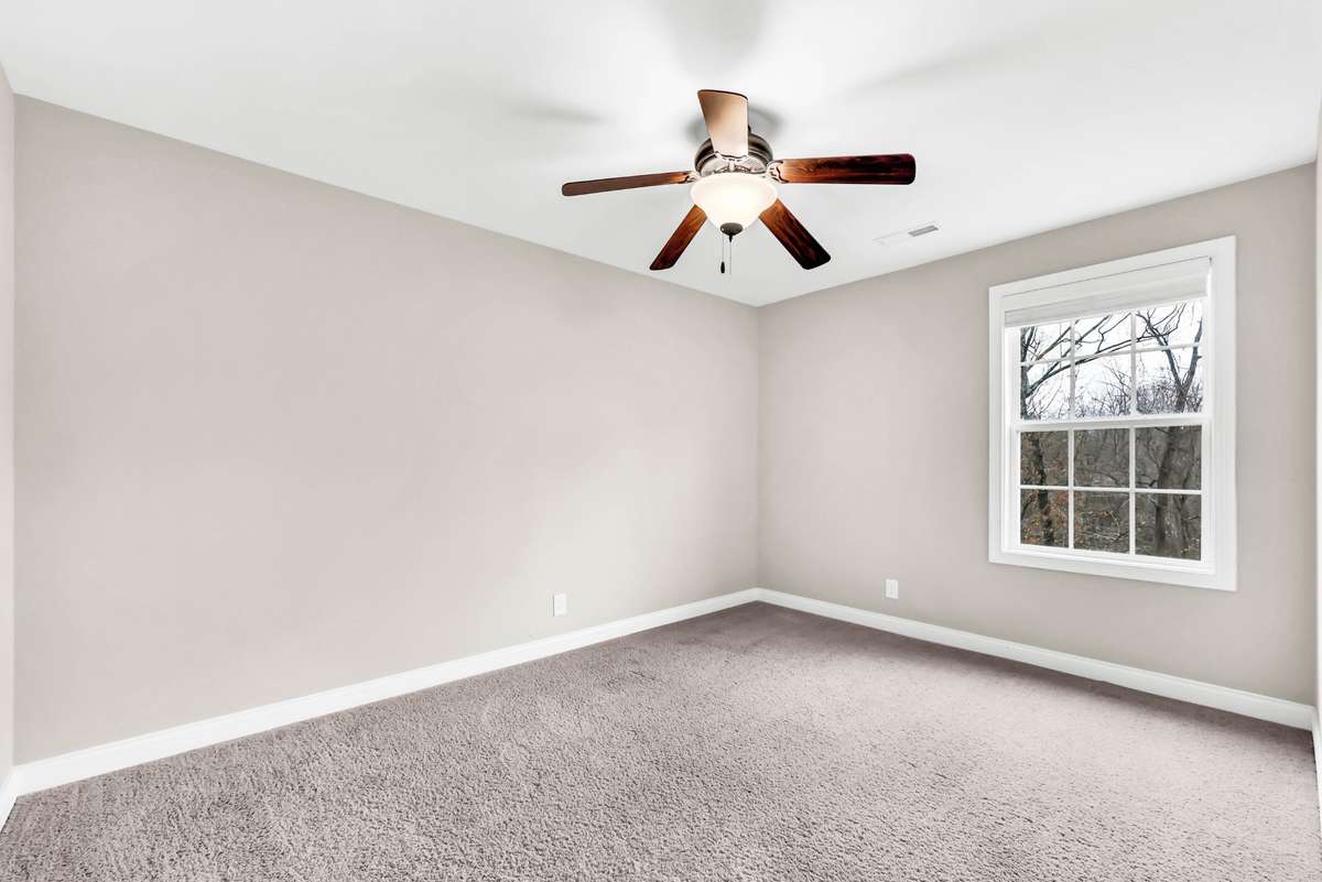 Bedroom two with ceiling fan. Buyer to select flooring for all carpeted areas, which is on-site.