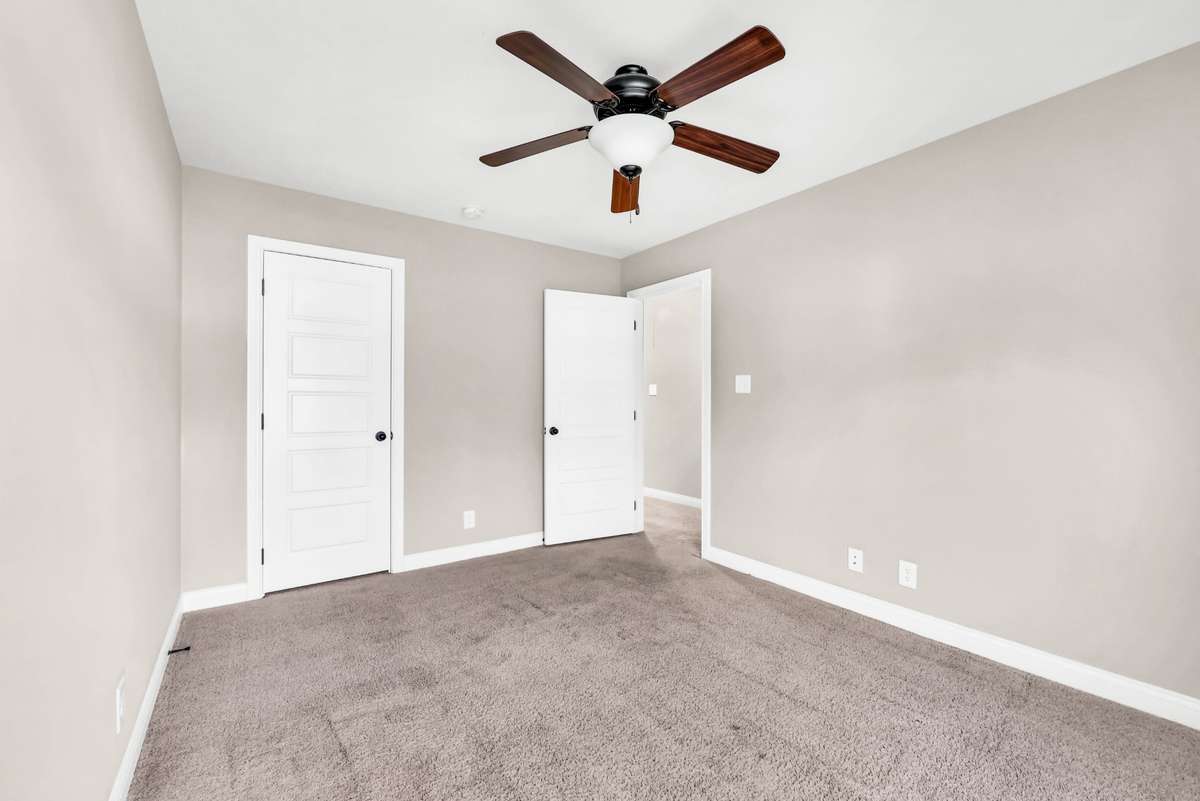 Bedroom two with ceiling fan. Buyer to select flooring for all carpeted areas, which is on-site.
