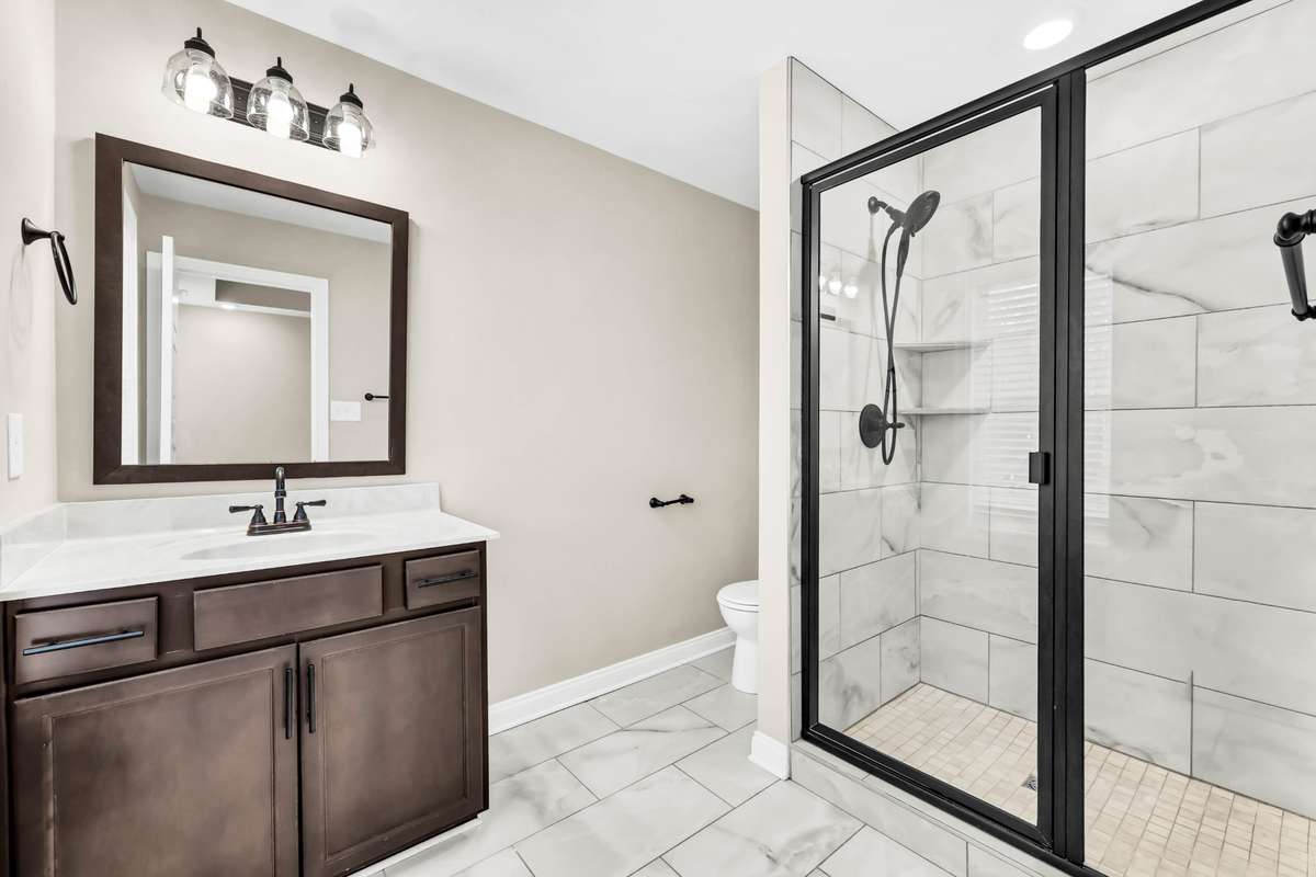 Full bathroom in primary suite with tile flooring and big walk-in tile shower