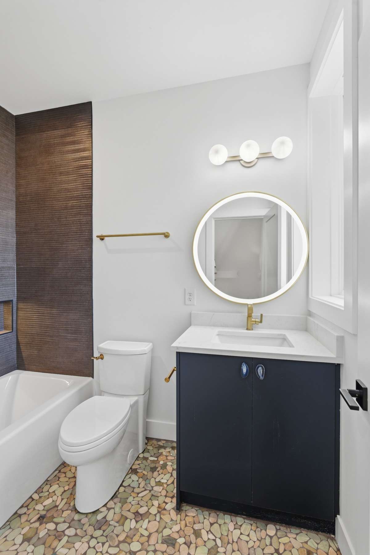 Bathroom 2: Statement tilework and warm, layered textures create a one-of-a-kind guest bath -  thoughtfully designed with custom designer details throughout and front-light mirror.
