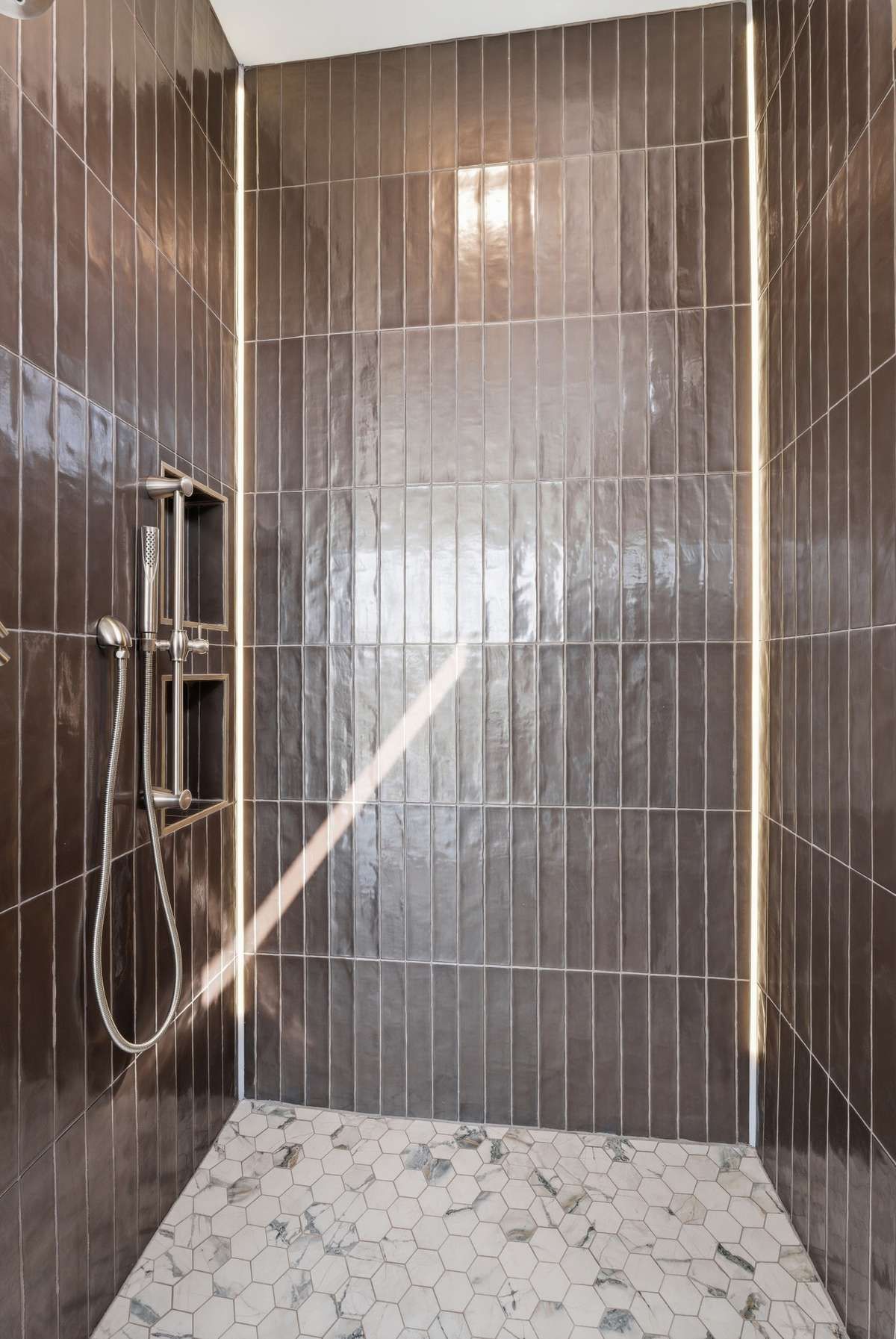Incredible walk-in shower with designer tile, LED lighting and built-in shower niches.