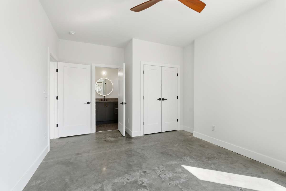 Bedroom 4: Lower level bedroom with polished concrete floor.
