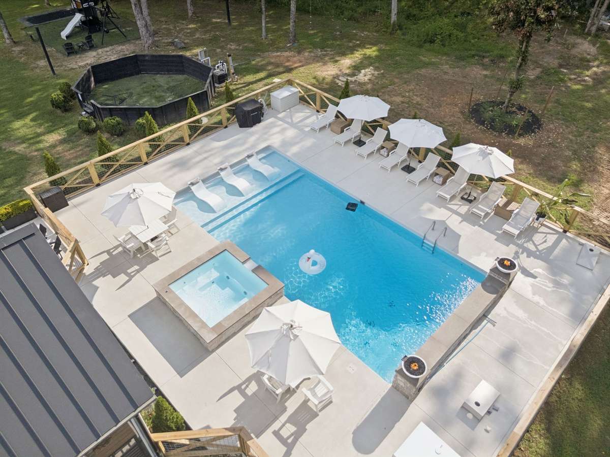 New ground pool with built in loungers, hot tub, gas firepits and custom lighting.