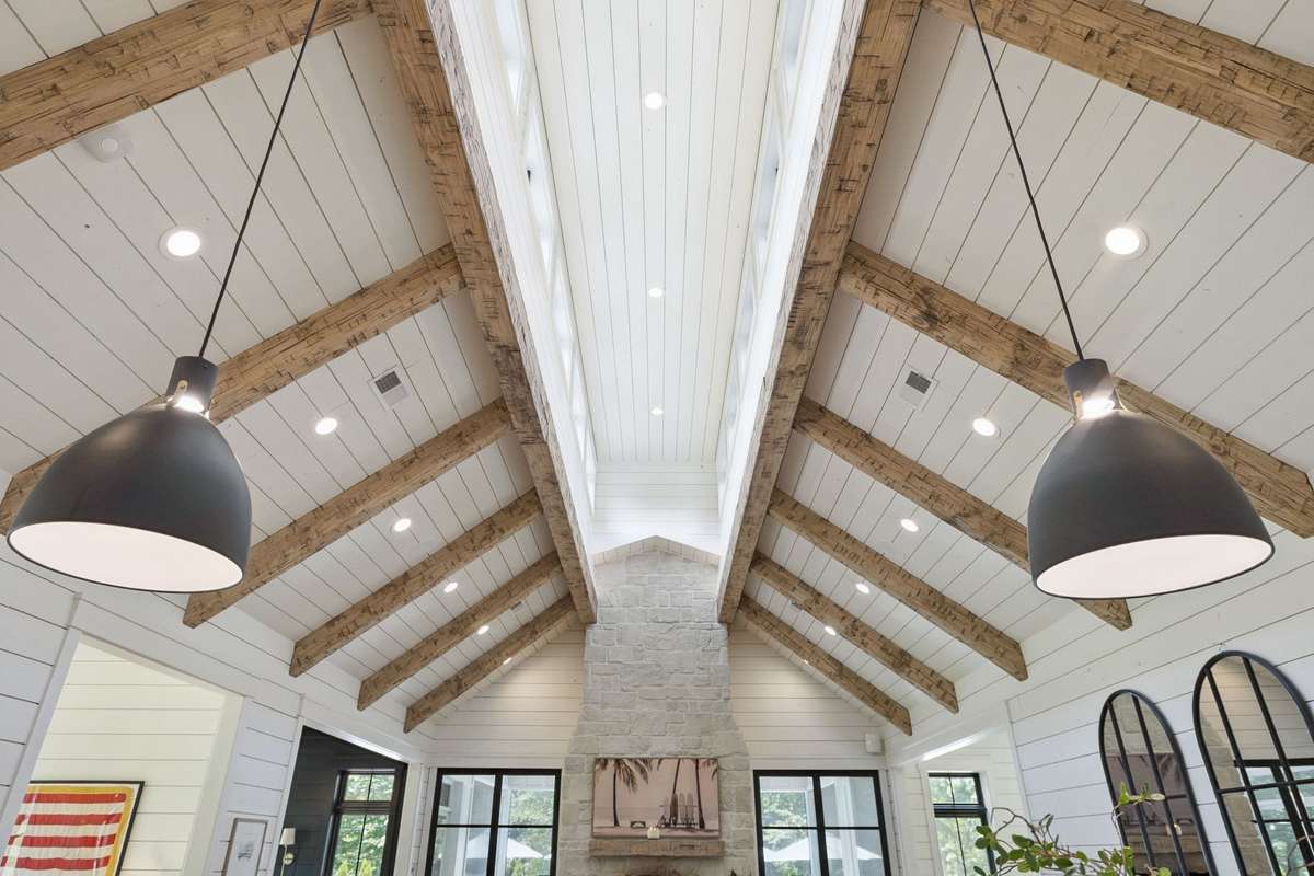 View of the exposed ceiling with natural light spilling into the living room/kitchen space.