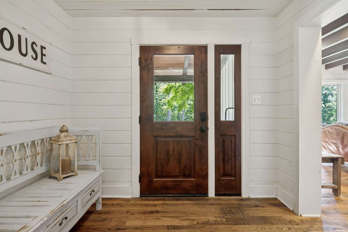 Entry foyer with beautiful hardwood floors and shiplap walls.