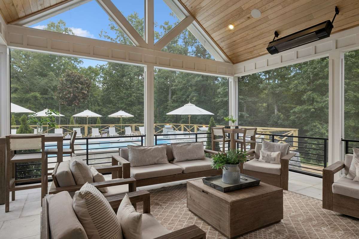 Screened in porch with gas heating units, custom shades that can be raised overlooking the unground pool area.