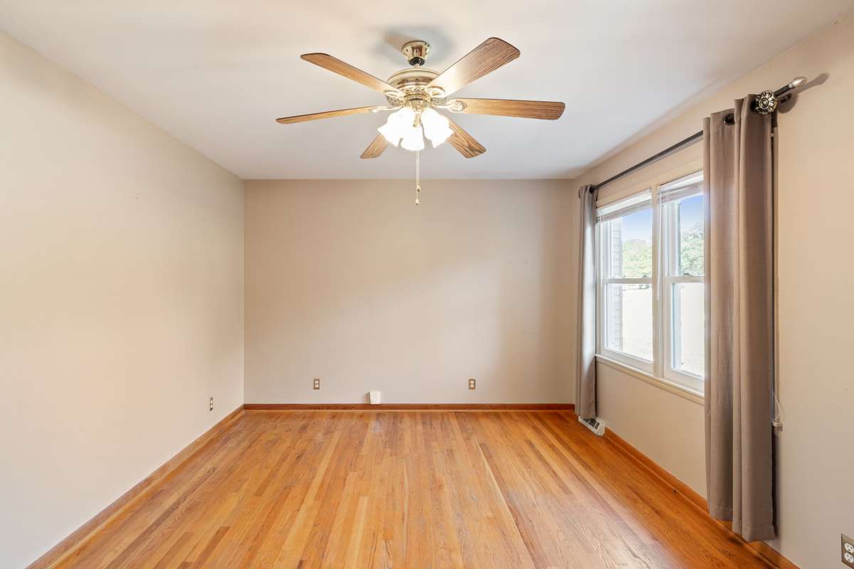 Long view of Living Room showing ceiling fan and large windows