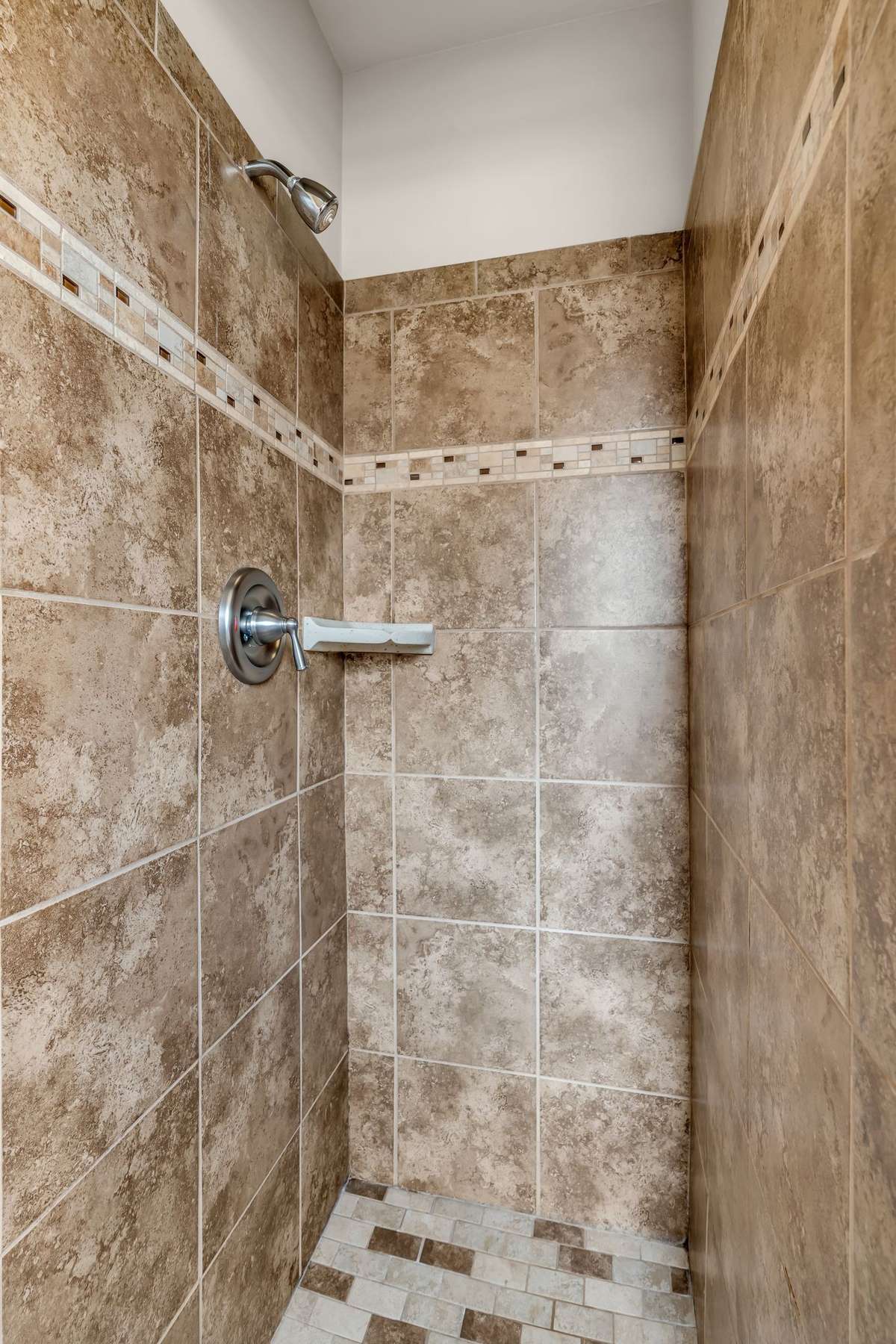 Tiled shower inside primary bathroom