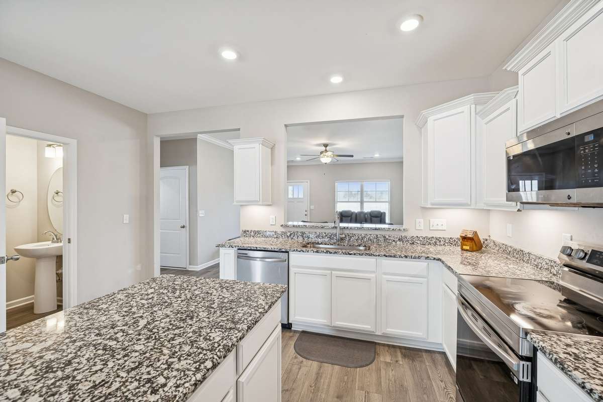 Thoughtfully designed kitchen features an abundance of white cabinetry with granite counters and loads of recessed lighting! 501 Ruby Cate Way, Murfreesboro, TN 37128