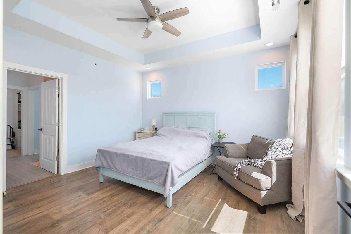 Spacious secondary primary suite with tray ceiling, natural light, and luxury vinyl plank!