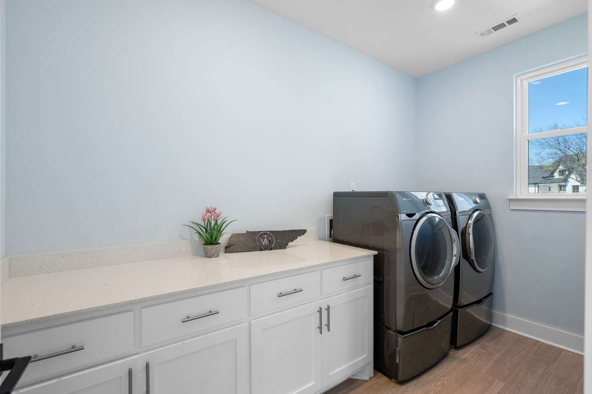 Bright laundry room with cabinetry and ample folding space!