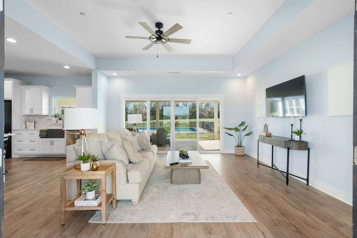 Bright, open living space with tray ceiling and picturesque backyard views of the pool!