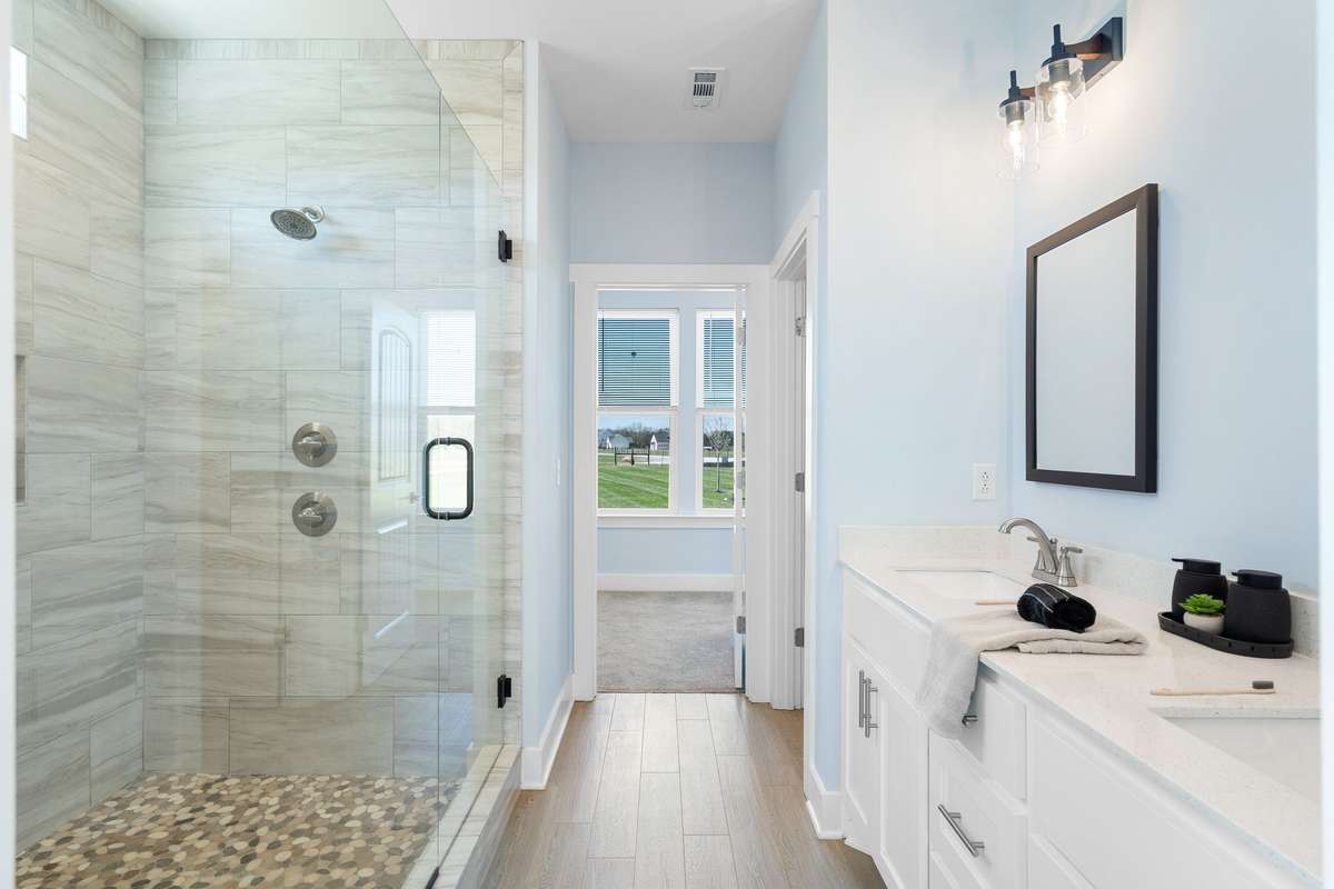 Walk-in tiled shower with glass enclosure.