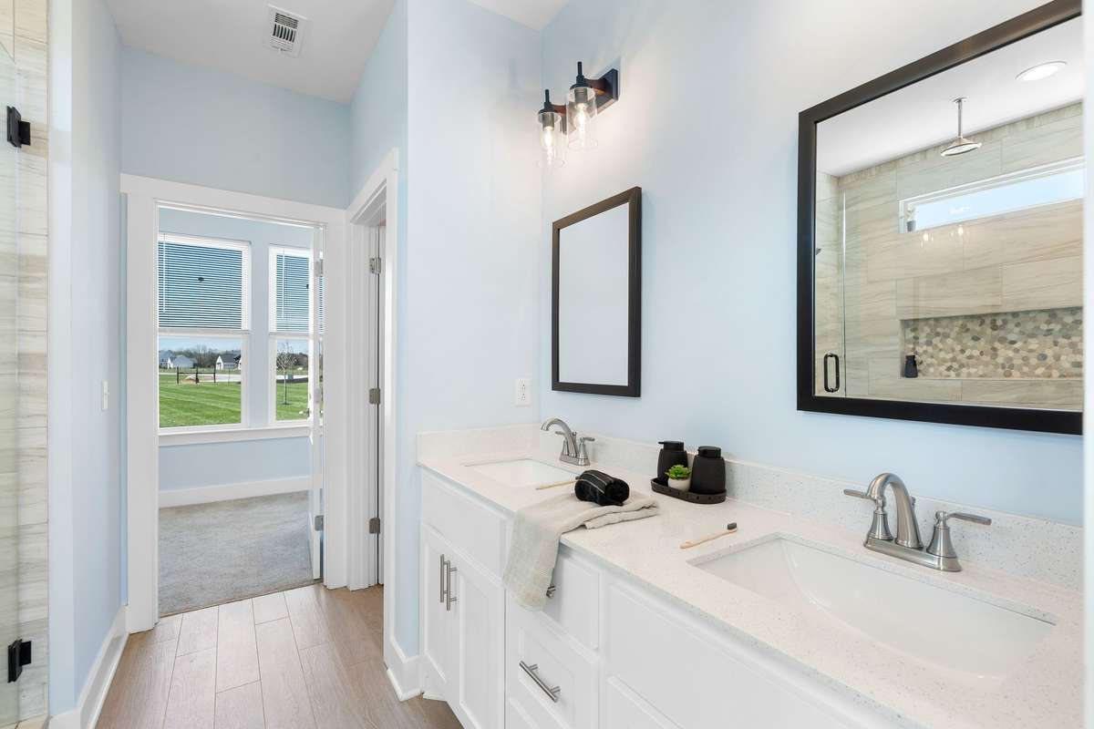 Bright primary bath with dual vanities and modern finishes.