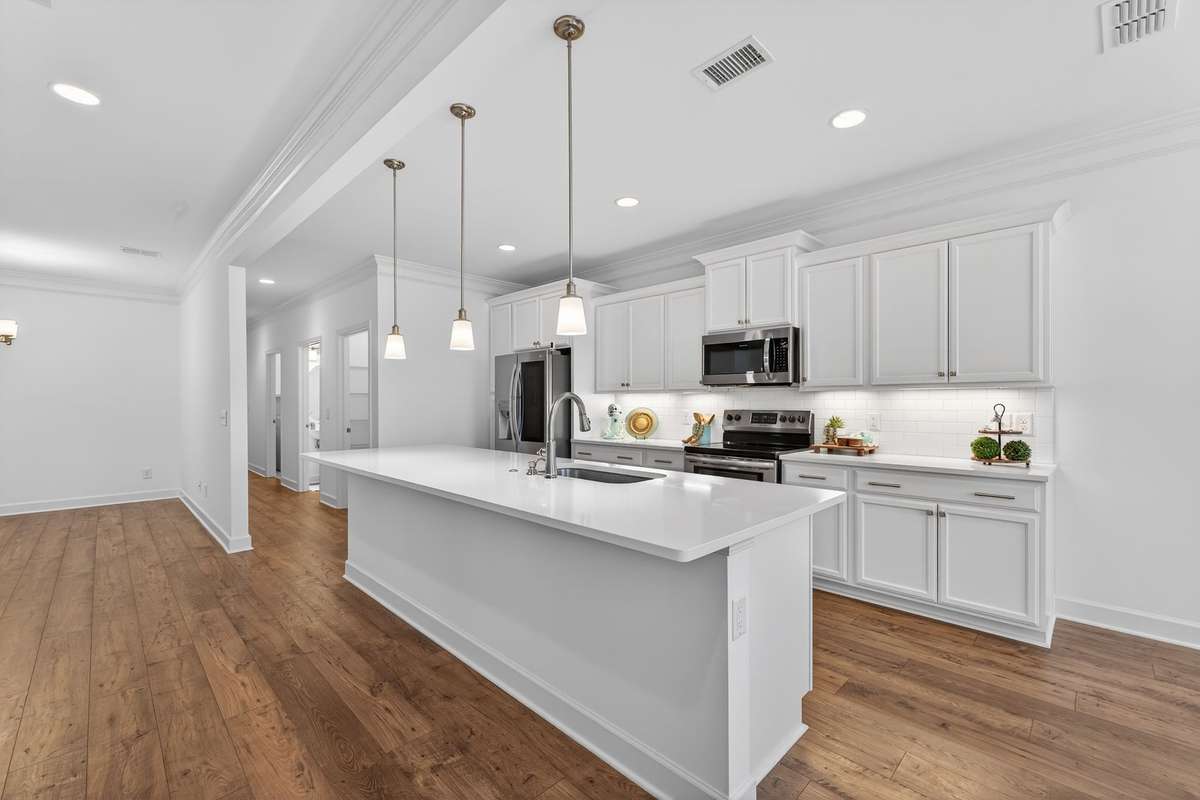 Kitchen and Hallway that leads to Walk-in Pantry, Powder Room, Laundry Room and Flex Room which would make a great Drop Zone/Mud room right off the garage.