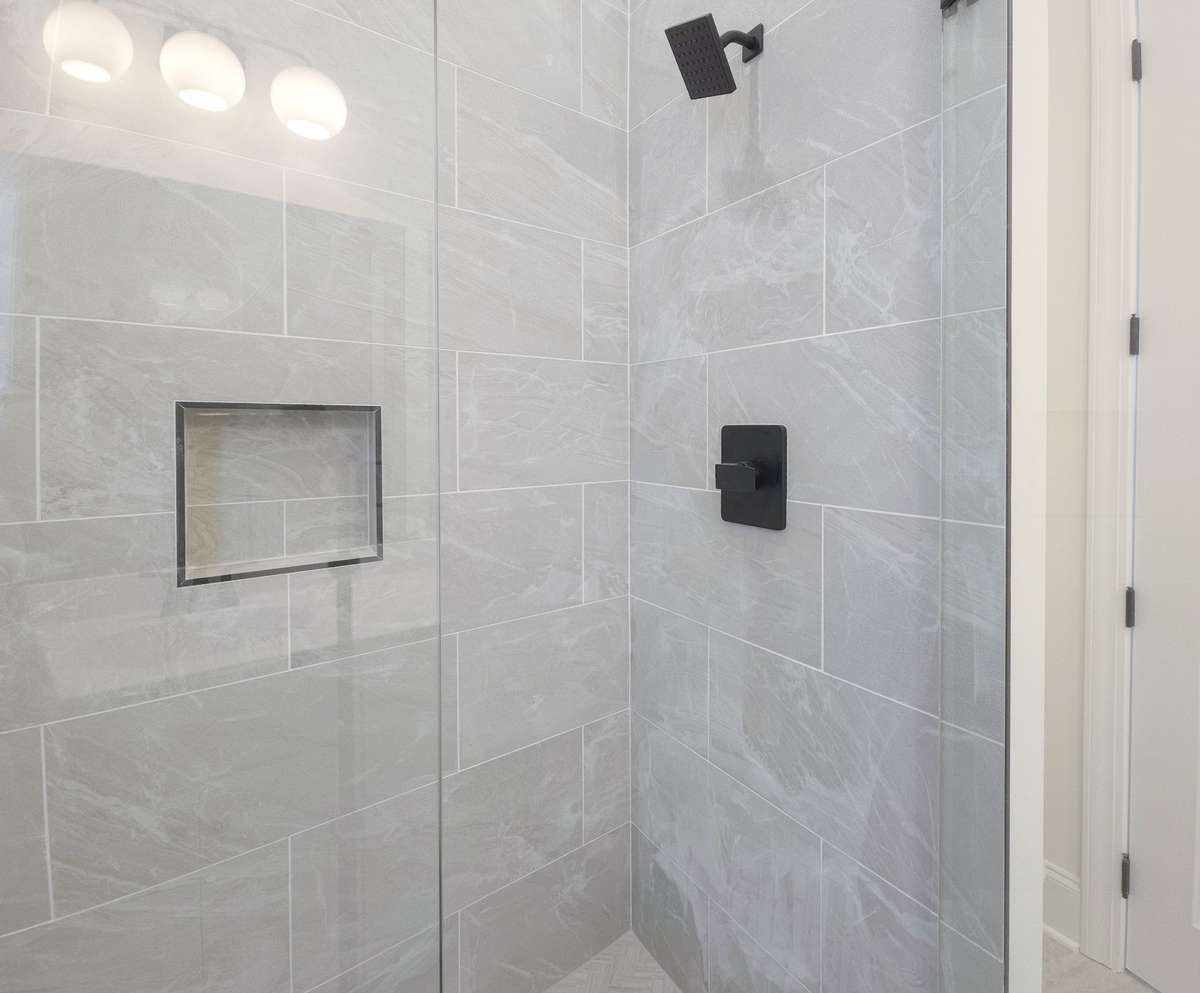 A fully tiled, glass enclosure with built-in storage makes every part of this home feel like luxury.