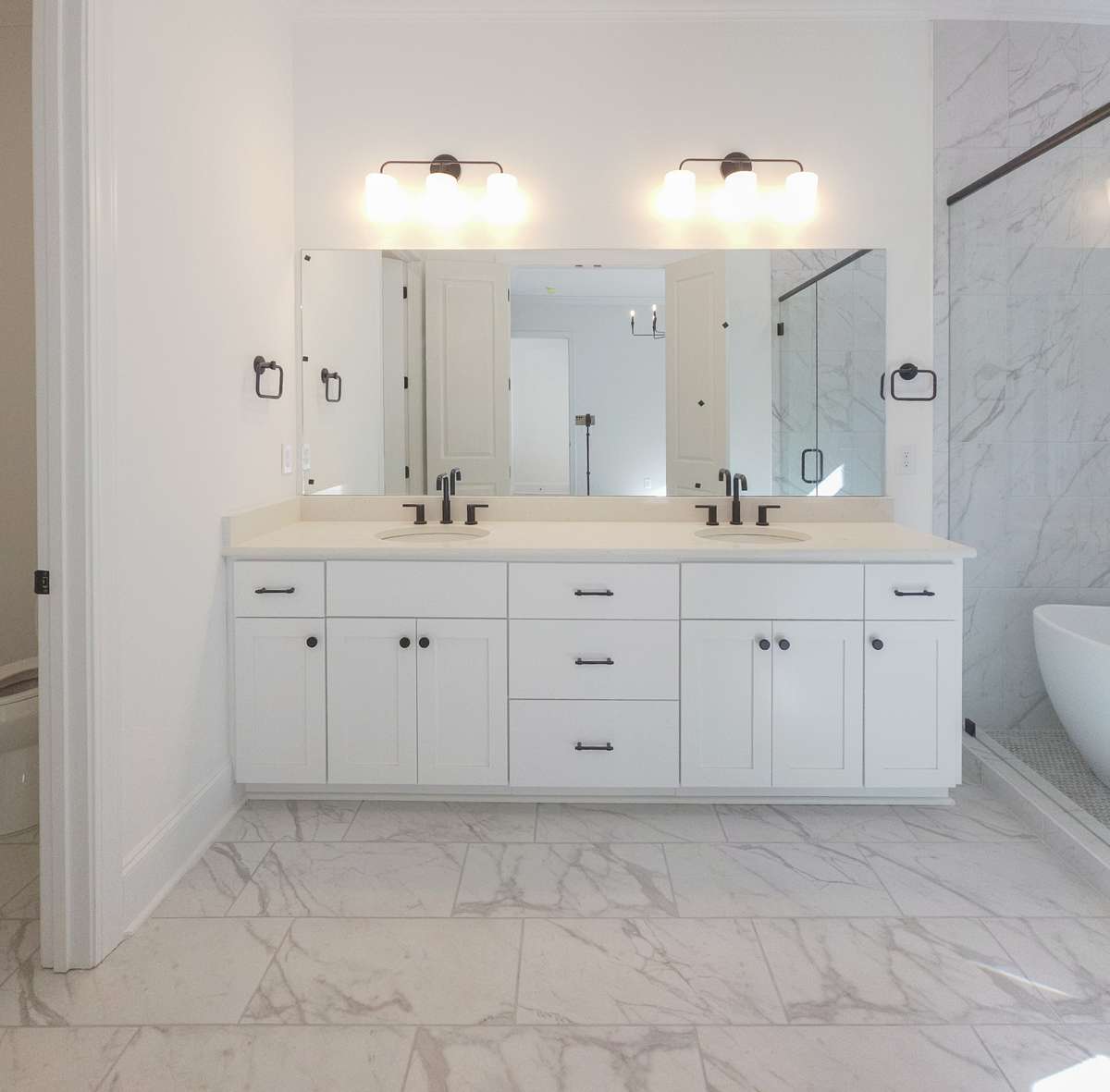 Enjoy double vanities with quartz countertops, custom tile, and a wet room with a soaking tub!